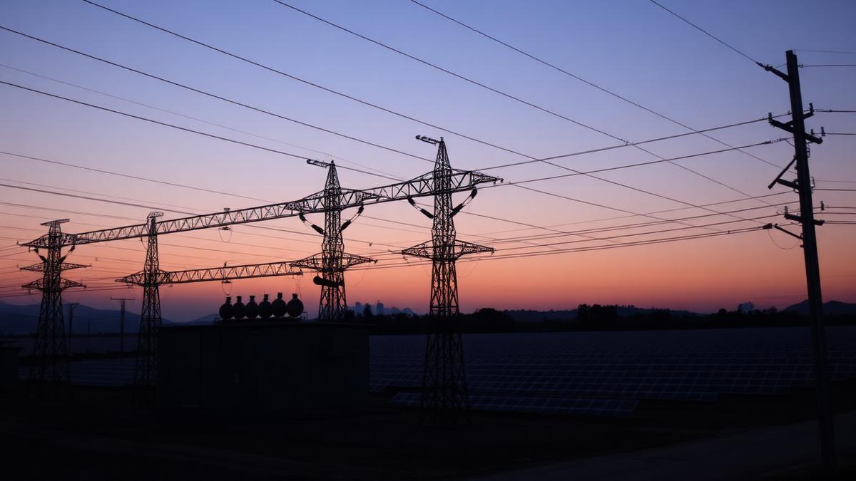 Electrical distribution substation with overhead lines against a clear sky at golden hour
